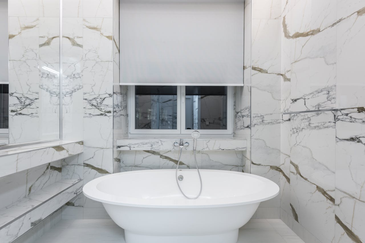 Modern bathroom featuring a luxurious marble design and a sleek freestanding bathtub.